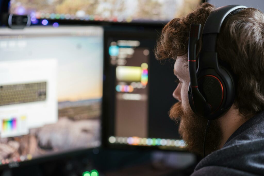 Man wearing headphones looking at computer monitor